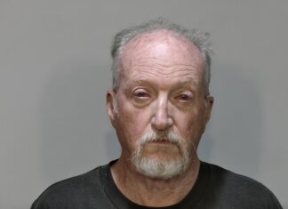 a man in a black t - shirt is shown in a mug shot