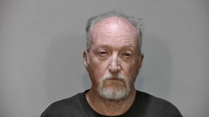 a man in a black t - shirt is shown in a mug shot