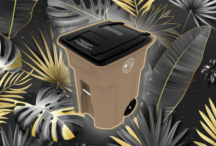 a trash can surrounded by tropical leaves