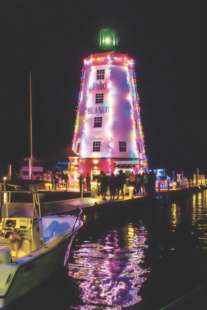 a light house is lit up on the water