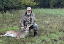 a man kneeling down next to a deer