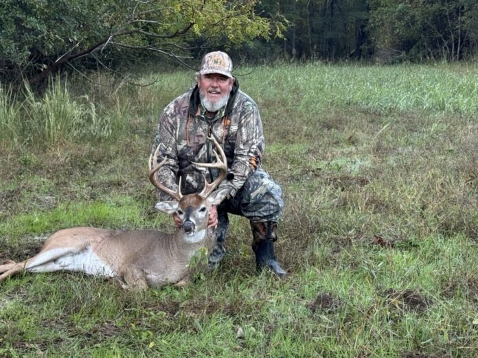 a man kneeling down next to a deer