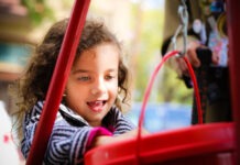 a little girl is playing on a playground