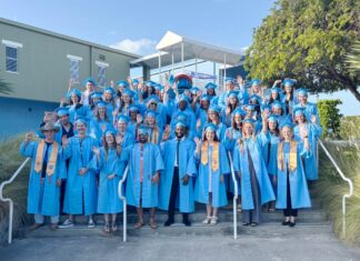 a group of people in blue graduation gowns posing for a picture