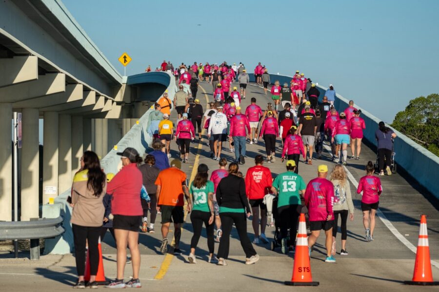 a group of people that are walking across a bridge