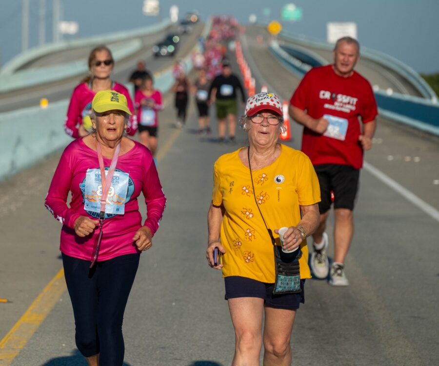 a group of people running on a bridge