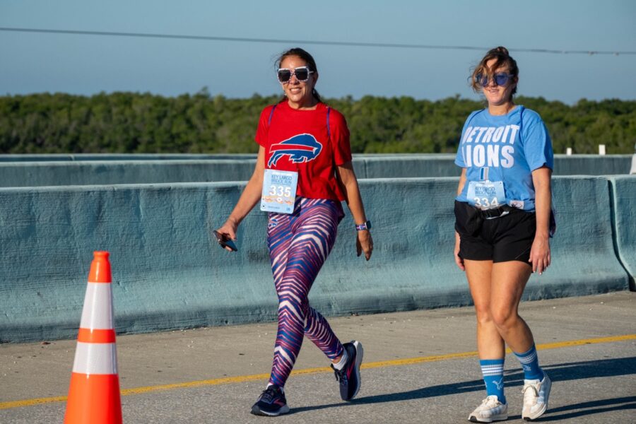 a couple of women walking across a bridge