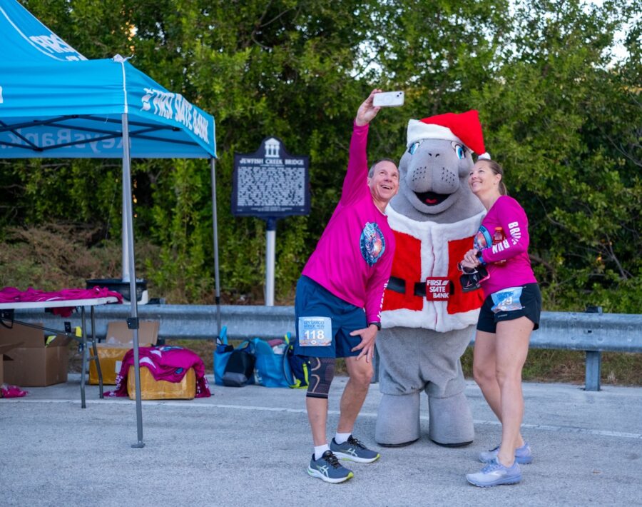 a couple of women standing next to a mascot