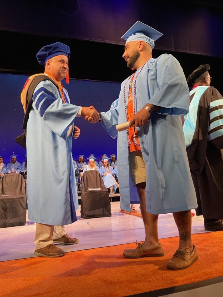 a couple of men shaking hands on top of a stage