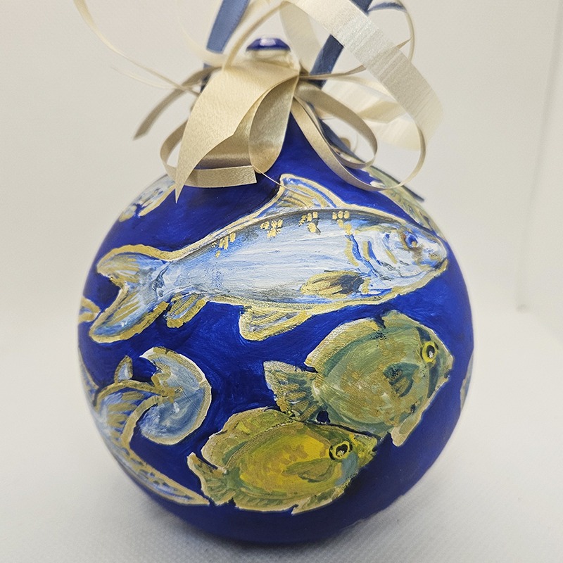 a blue ornament with fish painted on it