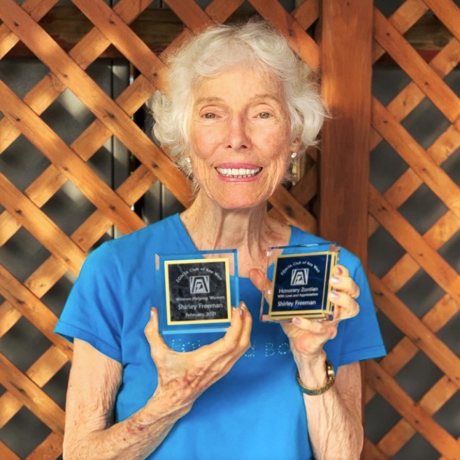 a woman holding two plaques in her hands