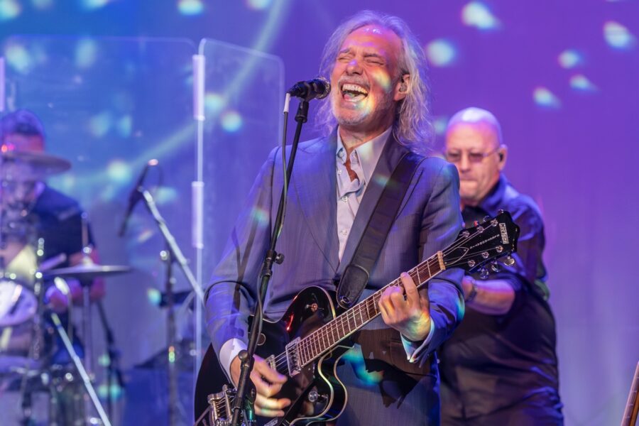 a man that is standing up with a guitar