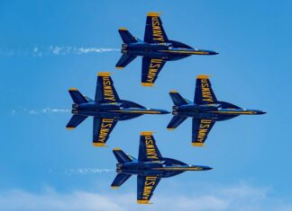 a group of jets flying through a blue sky