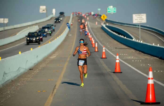 a woman running down a road with traffic cones