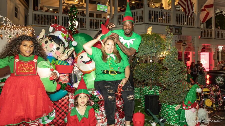 a group of people standing around a christmas tree