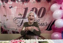 a woman sitting at a table in front of a cake