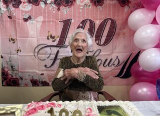 a woman sitting at a table in front of a cake