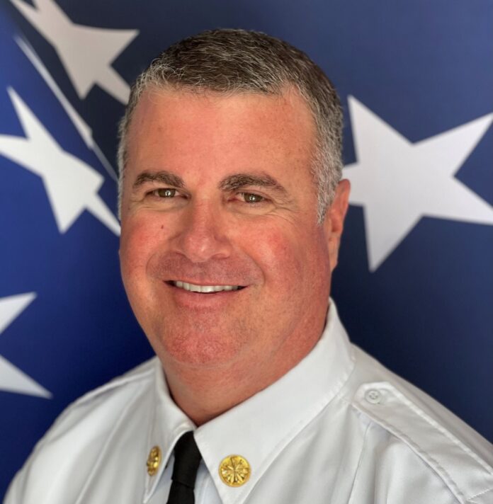 a man in a uniform standing in front of a flag