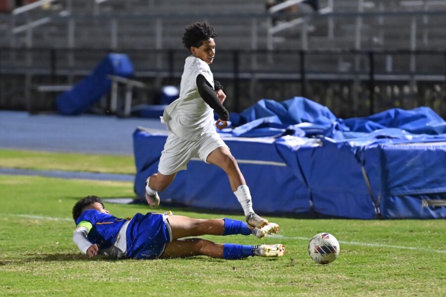 two men playing soccer on a soccer field