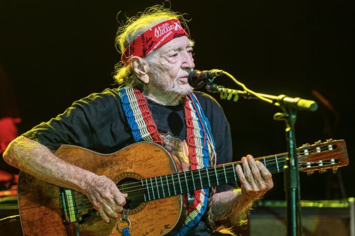 a man with a bandana playing a guitar