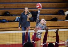 a group of young people playing a game of volleyball