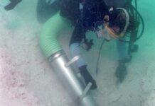 a man in a wet suit is holding a scuba tube