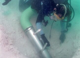 a man in a wet suit is holding a scuba tube