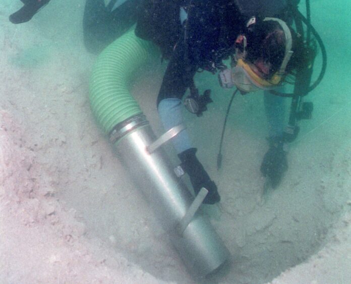 a man in a wet suit is holding a scuba tube