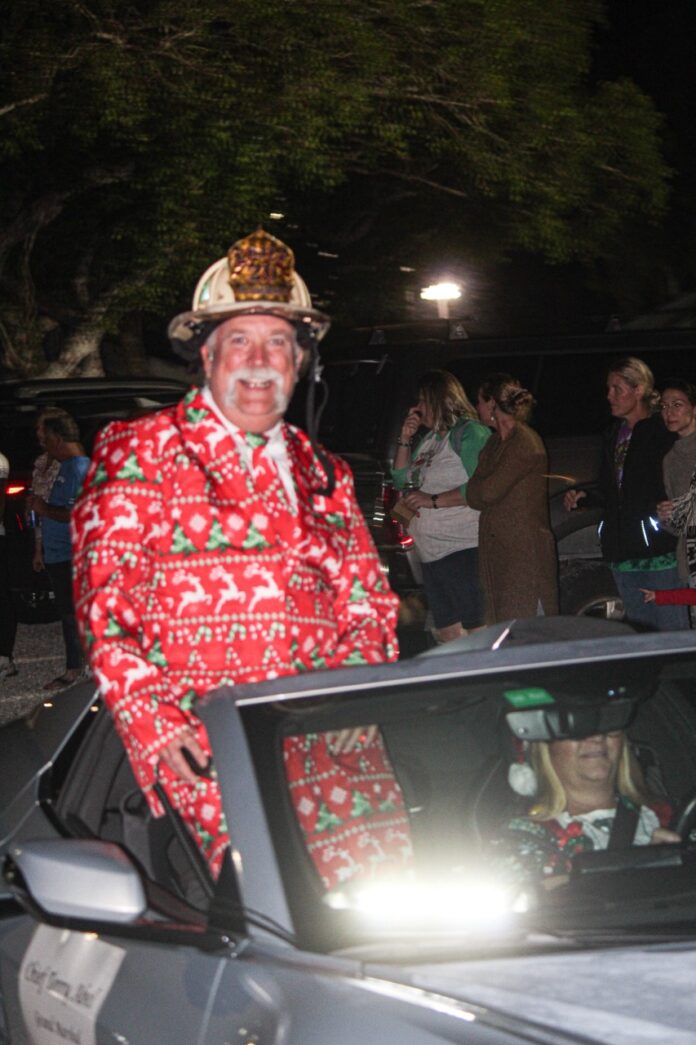 a man in a red and green suit is sitting in a car