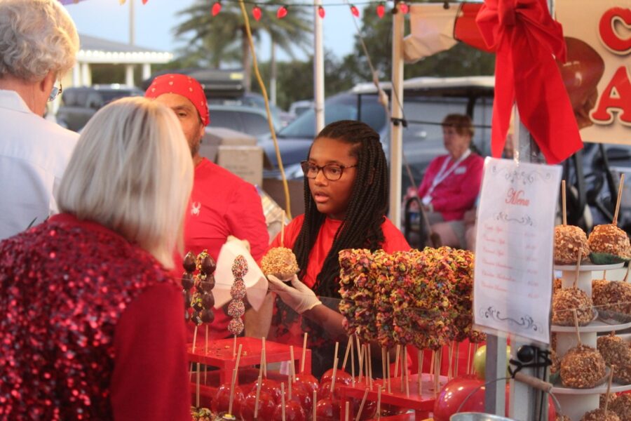 a group of people standing around a table filled with candy