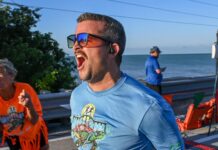 a man in a blue shirt is running by the water