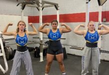 a group of women standing next to each other in a gym