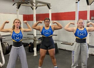 a group of women standing next to each other in a gym