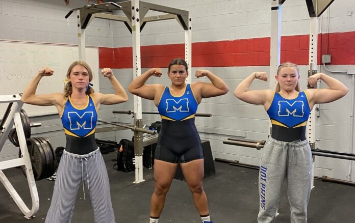 a group of women standing next to each other in a gym