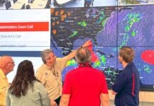 a group of people looking at a weather map