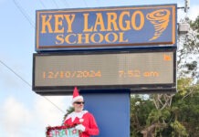 a man dressed as a santa clause holding a sign