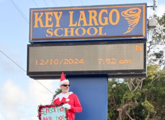 a man dressed as a santa clause holding a sign