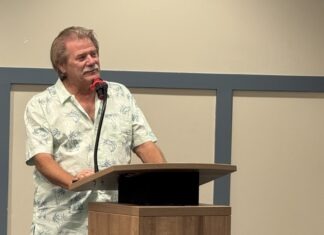 a man standing at a podium with a microphone