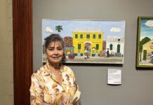 a woman standing in front of paintings on a wall