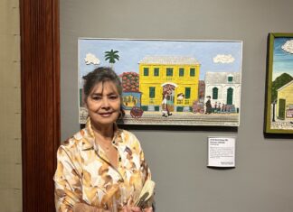 a woman standing in front of paintings on a wall