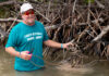 a man in a blue shirt is holding a rope in the water