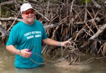 a man in a blue shirt is holding a rope in the water