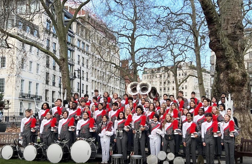 a group of men and women in red and white outfits standing in front of a