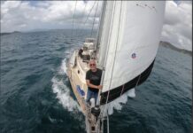 a man sitting on the front of a sailboat