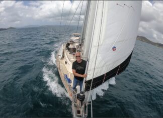 a man sitting on the front of a sailboat