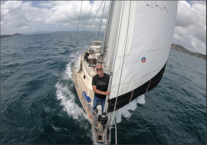 a man sitting on the front of a sailboat