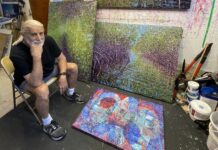 a man sitting in a chair next to a painting