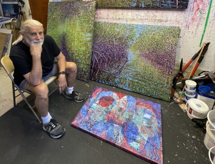 a man sitting in a chair next to a painting