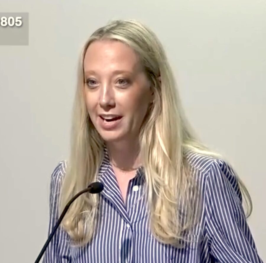 a woman standing at a podium with a microphone