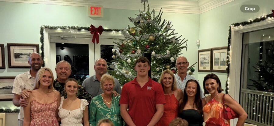 a group of people standing in front of a christmas tree